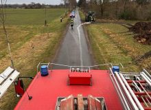 Feuerwehr im Einsatz mit IMSORB Ölbindemittel auf Landstraße zur Beseitigung von Ölspur