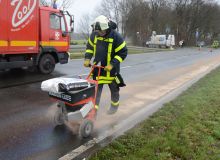 Feuerwehr streut IMSORB Ölbindemittel mit Streuwagen zur Aufnahme von Öl auf der Fahrbahn