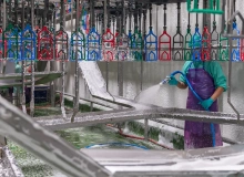 Mitarbeiter reinigt Industrieanlage mit IMSORB Industriereiniger und Wasserstrahl zur Entfernung von Verschmutzungen