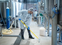 Mitarbeiter nutzt IMSORB Industriereiniger zur Reinigung von Böden in industrieller Produktionsanlage